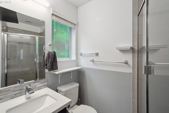 bathroom featuring a shower stall, decorative backsplash, vanity, and toilet
