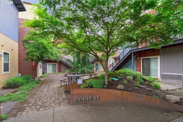 view of home's community featuring stairs and a patio
