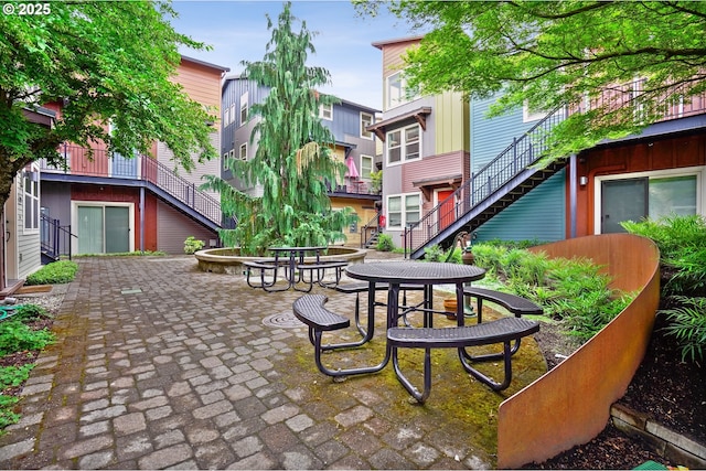 view of property's community with stairway and a patio area