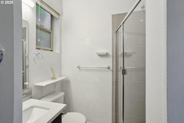 bathroom featuring toilet, tiled shower, and vanity