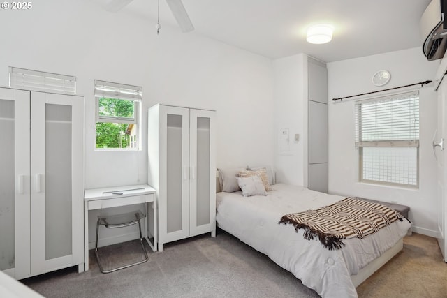 bedroom featuring light colored carpet and two closets