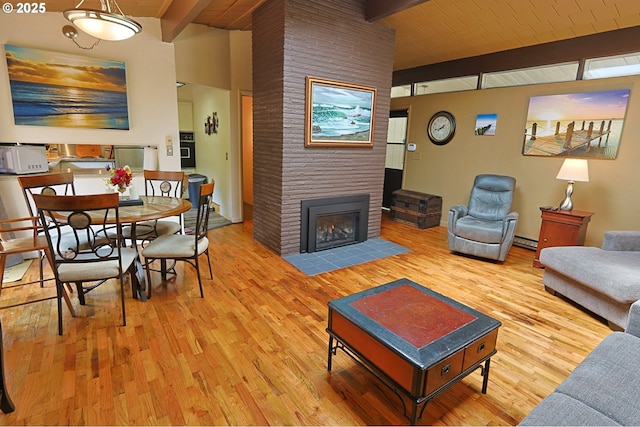 1695 N 17th St, Coos Bay, OR 97420 - living room with beam ceiling, wood finished floors, a large fireplace, and a baseboard radiator