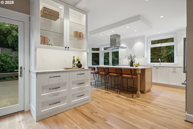 3505 SW Beaverton Ave, Portland, OR 97239 - bar area with island exhaust hood, light wood-style floors, recessed lighting, and backsplash