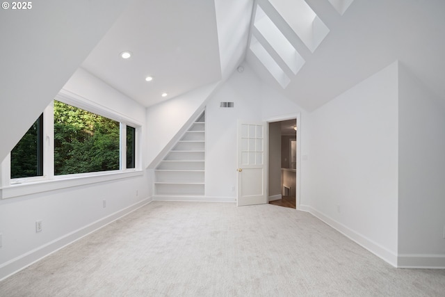 3505 SW Beaverton Ave, Portland, OR 97239 - unfurnished living room featuring a skylight, carpet floors, built in features, stairs, and high vaulted ceiling
