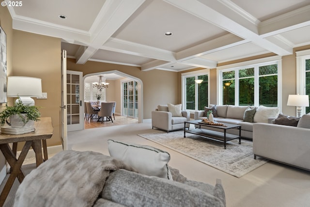 3505 SW Beaverton Ave, Portland, OR 97239 - carpeted living room featuring coffered ceiling, a chandelier, arched walkways, beam ceiling, and ornamental molding