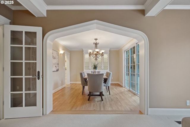 3505 SW Beaverton Ave, Portland, OR 97239 - dining space with ornamental molding, a chandelier, wood finished floors, and arched walkways