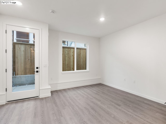 empty room with recessed lighting, wood finished floors, and baseboards