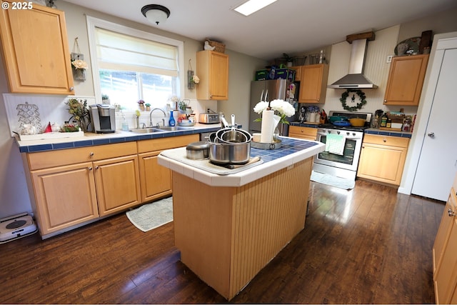 kitchen with tile countertops, stainless steel appliances, light brown cabinets, a sink, and wall chimney exhaust hood