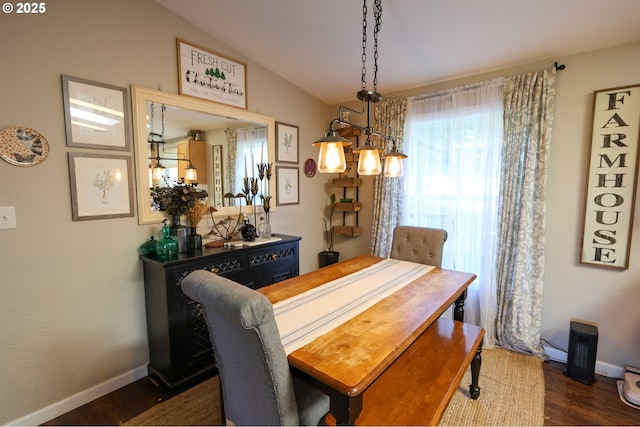 dining area featuring vaulted ceiling, dark wood-style flooring, and baseboards