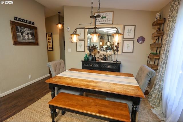 dining room with vaulted ceiling, baseboards, and wood finished floors