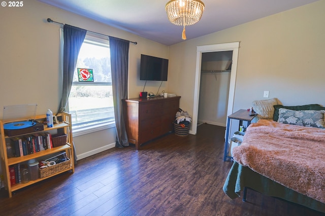 bedroom with lofted ceiling, a notable chandelier, a closet, and wood finished floors