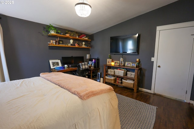 bedroom with lofted ceiling, baseboards, and wood finished floors