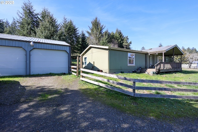 manufactured / mobile home with metal roof, an outdoor structure, and fence