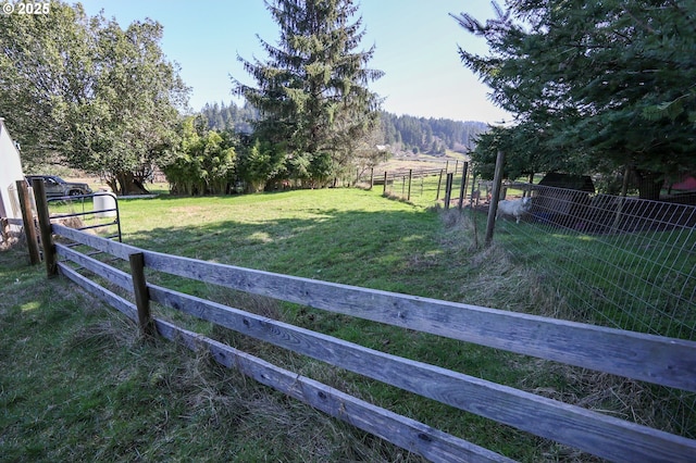 view of yard featuring a rural view and fence