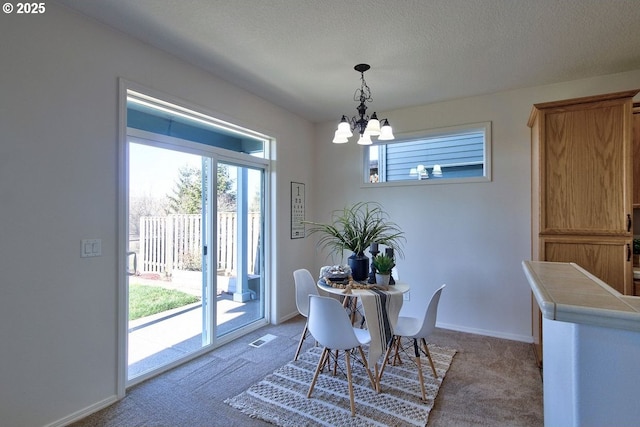 dining space with visible vents, light carpet, a textured ceiling, baseboards, and a chandelier