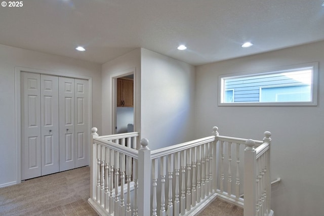 hallway featuring recessed lighting, an upstairs landing, and carpet