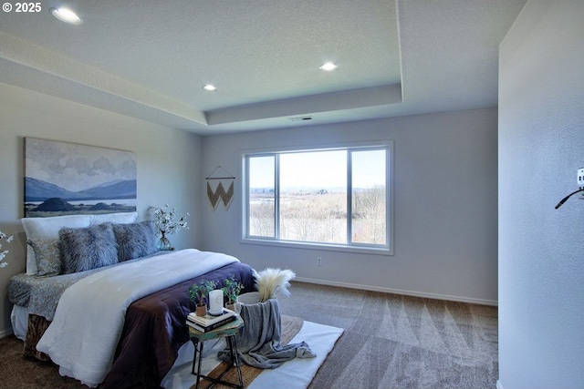 bedroom featuring a tray ceiling, a textured ceiling, recessed lighting, carpet, and baseboards