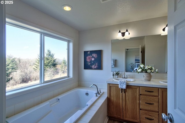 bathroom featuring a bath, double vanity, and a sink