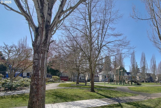 surrounding community with playground community, a residential view, and a lawn