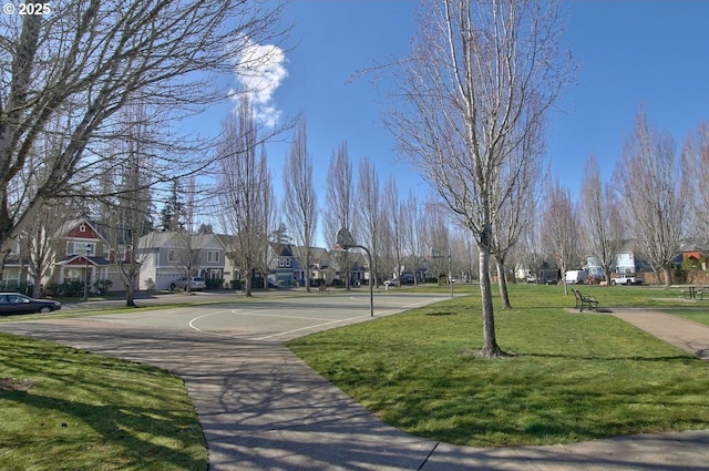 view of community featuring a residential view, a lawn, and community basketball court