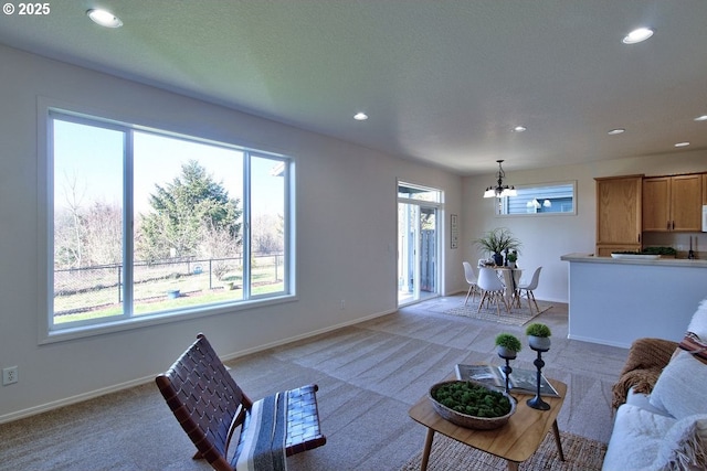 living area featuring a notable chandelier, recessed lighting, baseboards, and light carpet