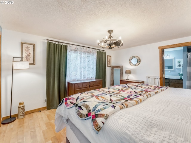 bedroom with an inviting chandelier, a textured ceiling, baseboards, and light wood-type flooring