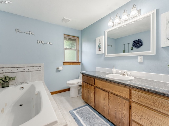 bathroom featuring a tub with jets, vanity, toilet, and baseboards