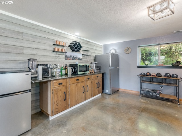 kitchen featuring a textured ceiling, brown cabinetry, open shelves, concrete floors, and appliances with stainless steel finishes