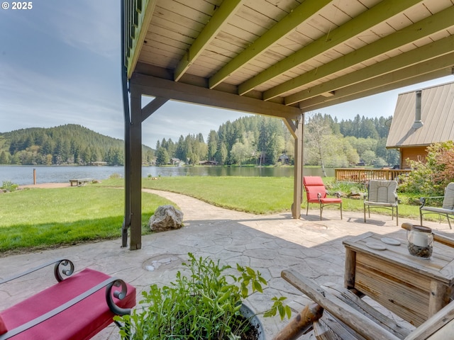 view of patio / terrace with a water view and a forest view