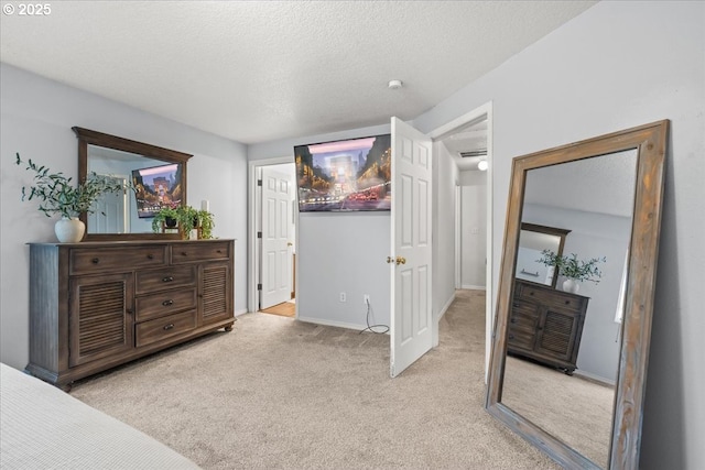 bedroom featuring light carpet, baseboards, and a textured ceiling