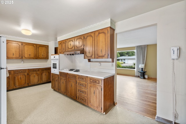 1627 NE 143rd Ave, Portland, OR 97230 - kitchen featuring white appliances, brown cabinetry, light countertops, and under cabinet range hood