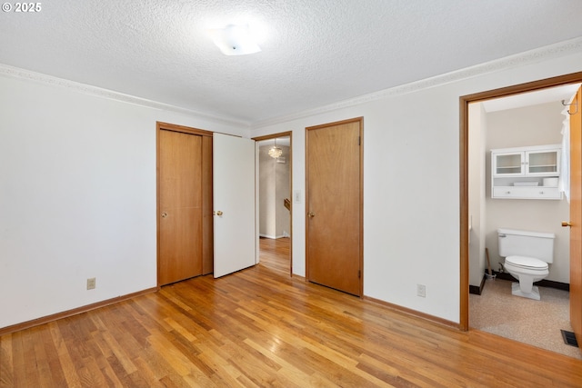 1627 NE 143rd Ave, Portland, OR 97230 - unfurnished bedroom featuring multiple closets, light wood-style floors, a textured ceiling, ensuite bathroom, and baseboards