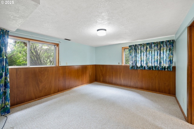 1627 NE 143rd Ave, Portland, OR 97230 - spare room featuring wooden walls, a textured ceiling, carpet, and wainscoting