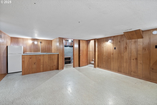 1627 NE 143rd Ave, Portland, OR 97230 - finished below grade area featuring freestanding refrigerator, a textured ceiling, and wood walls