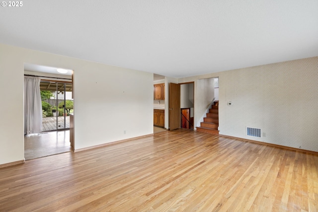 1627 NE 143rd Ave, Portland, OR 97230 - empty room with light wood finished floors, stairway, and baseboards