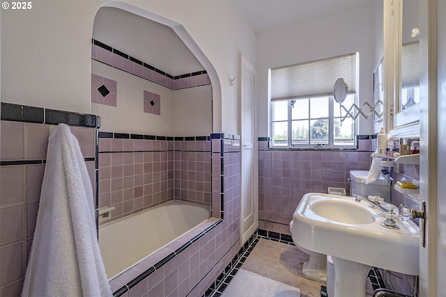 bathroom featuring tiled shower / bath combo, tile walls, and tile patterned flooring