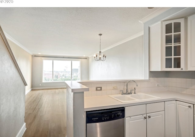 kitchen with dishwasher, a sink, crown molding, white cabinetry, and glass insert cabinets