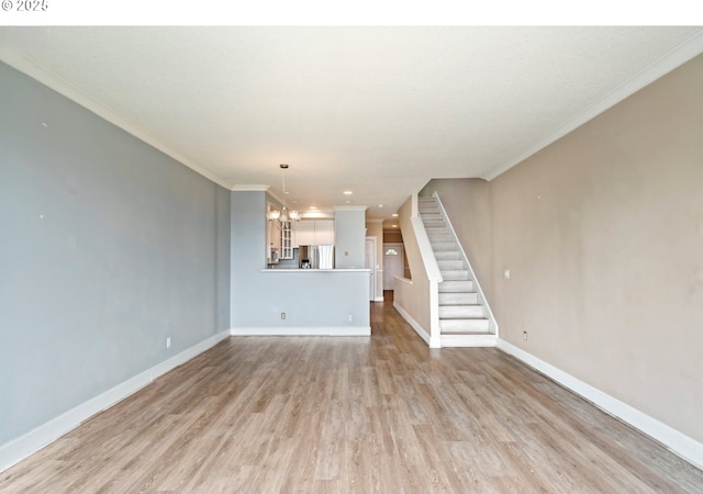 unfurnished living room featuring light wood-style flooring, a chandelier, baseboards, stairs, and ornamental molding