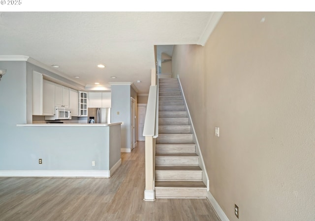 staircase with baseboards, crown molding, wood finished floors, and recessed lighting