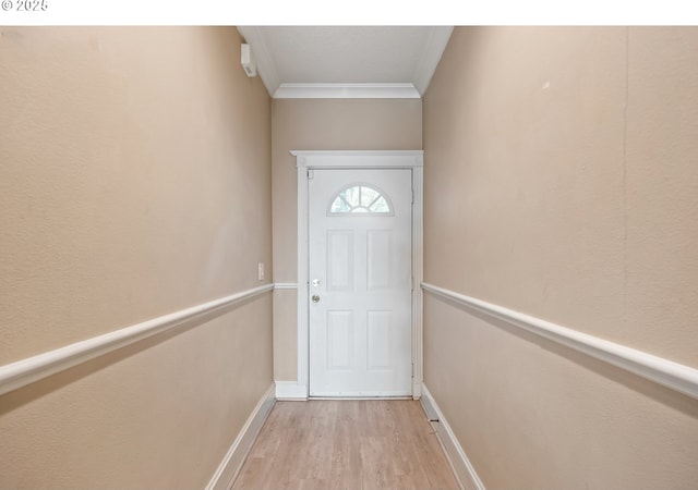 doorway with crown molding, light wood finished floors, and baseboards