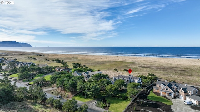 birds eye view of property with a water view and a view of the beach