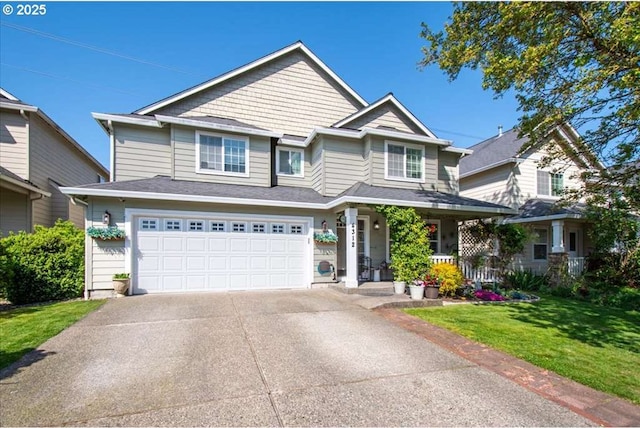 view of front of home featuring a porch, an attached garage, a front yard, and concrete driveway
