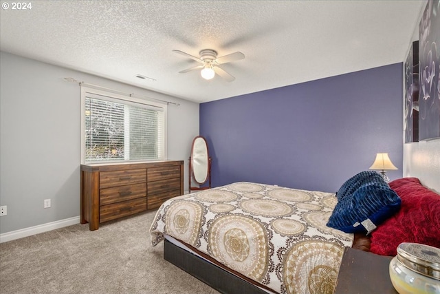 carpeted bedroom featuring baseboards, a ceiling fan, a textured ceiling, and visible vents