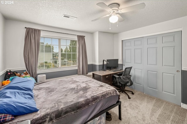 bedroom featuring carpet floors, a ceiling fan, a textured ceiling, and visible vents