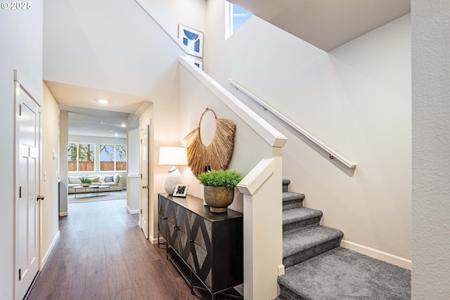 staircase featuring a high ceiling and hardwood / wood-style floors