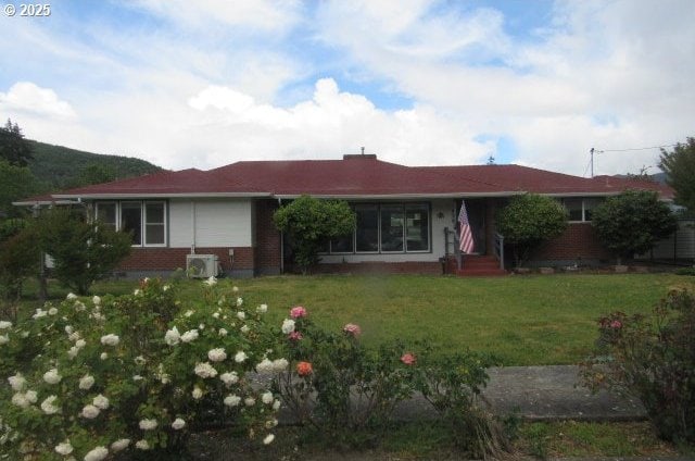 view of front of house with brick siding and a front yard