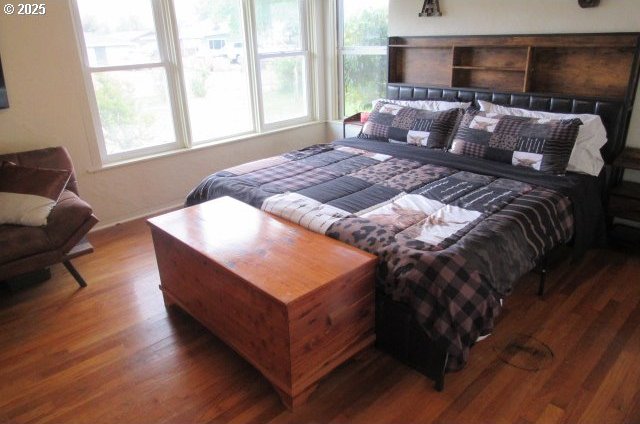 bedroom with wood finished floors and baseboards