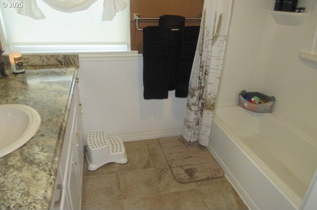 full bath featuring a wainscoted wall and vanity