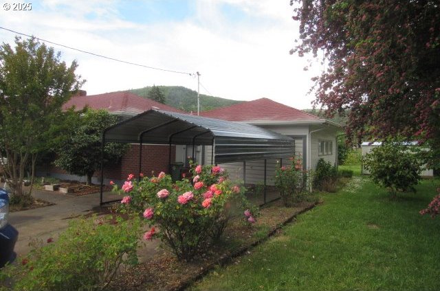 view of green lawn with a carport