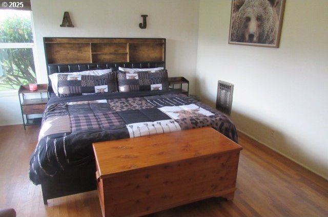 bedroom with wood finished floors, multiple windows, and baseboards
